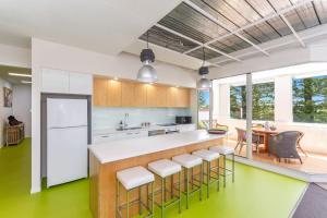 an open kitchen with a counter and stools at The Ritz in Yamba