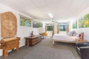a bedroom with a bed and a desk and windows at The Ritz in Yamba