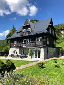 een groot houten huis met een schilddak bij Willa Mała Czarna in Wisła