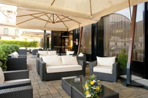 une terrasse avec des chaises, un parasol et une table dans l'établissement Hotel San Pietro, à Vérone