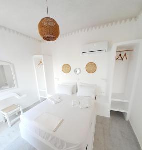 a white room with a white bed in it at Maroulis Studios in Mikri Vigla