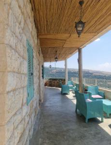 a patio with green chairs and a wooden ceiling at צימר old school בחרמון לזוגות ומשפחות in Ein Kinya