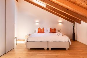 a bedroom with a white bed with orange pillows at Superior Beach Aparthotel in Lido di Jesolo