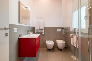 a bathroom with a red cabinet and a toilet at Superior Beach Aparthotel in Lido di Jesolo