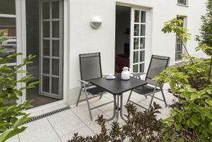 einen schwarzen Tisch und zwei Stühle auf einer Terrasse in der Unterkunft Apartment Residenz am Balmer See Wohnung 44 mit Wellnessbereich in Balm