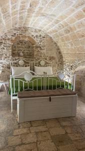 a bedroom with a bed in a stone wall at Pietrabianca Suite in Modugno