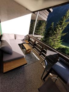 a room with a balcony with a couch and chairs at Superior Apartment Eva in Heiligenblut