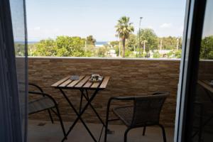a table and chairs on a balcony with a view of the ocean at Parthenis Riviera Hotel in Athens