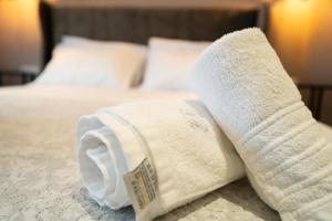 a rolled up towel on top of a bed at Parthenis Riviera Hotel in Athens