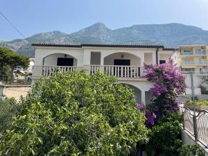 Casa con balcón con flores púrpuras en Apartments Anamarija, en Makarska