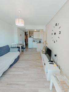 ein Wohnzimmer mit einem Bett und einem Schreibtisch mit einem TV in der Unterkunft Apartment in Torrevieja by the Beach in Torrevieja