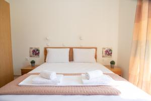 a bedroom with a large bed with two towels on it at Naxian Place in Agios Prokopios