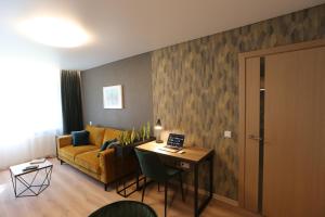 a living room with a couch and a table with a laptop at Modern 2 Room Apartment - FREE PARKING - NETFLIX in Alytus