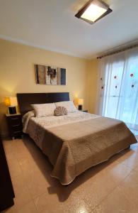 a bedroom with a large bed and a window at Piso familiar con amplia terraza 300m de la playa in Cullera