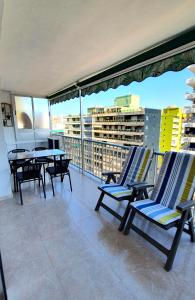 a balcony with chairs and tables on a building at Piso familiar con amplia terraza 300m de la playa in Cullera