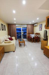 a living room with a couch and a table at Piso familiar con amplia terraza 300m de la playa in Cullera +29 photos