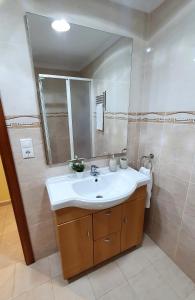 a bathroom with a sink and a mirror at Piso familiar con amplia terraza 300m de la playa in Cullera