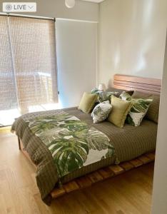 1 dormitorio con 1 cama con manta verde y almohadas en Apartamento Smart en Buenos Aires
