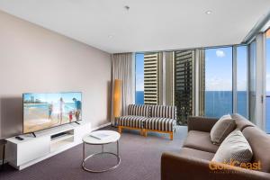 Una sala de estar con un sofá y un televisor. en Gold Coast Private Apartments - H Residences, Surfers Paradise, en Gold Coast