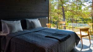 um quarto com uma cama e uma grande janela em The Barö em Inkoo