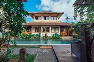 a house with a swimming pool in front of a house at Munari Resort Ubud in Ubud