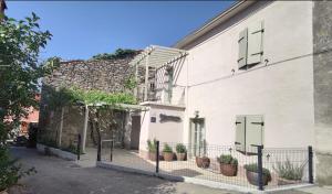 a white building with potted plants in front of it at Apartman Marinac in Roč