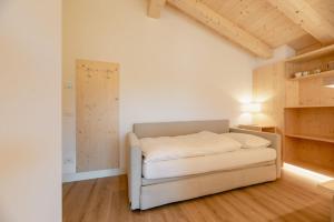 Un dormitorio con una cama blanca en una habitación con techos de madera. en Garnì Aurora Bed and Breakfast en Soraga