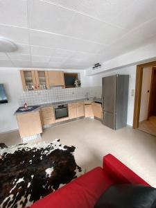 a kitchen with a refrigerator and a red couch at Reiter, Haus in Finkenberg