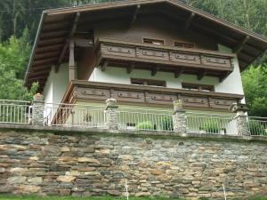 a house on a stone wall with a balcony at Reiter, Haus in Finkenberg