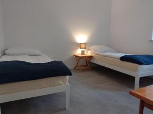 a bedroom with two beds and a lamp on a table at Guest House Ustka in Ustka