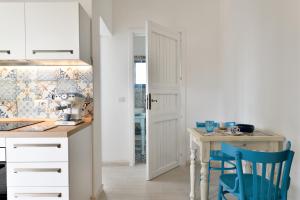 a kitchen with a table and blue chairs at Casa Vacanze il mirto in Bari Sardo