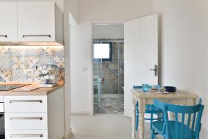 a kitchen with a table and blue chairs at Casa Vacanze il mirto in Bari Sardo