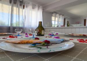 a table with a plate of food and a bottle of wine at Anthoula house in Vlachopoulátika +8 photos