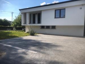 a white house with a driveway in front of it at Guest House Ustka in Ustka