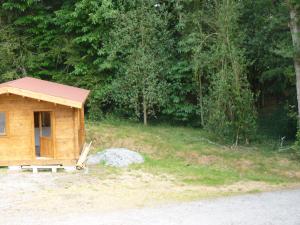 eine kleine Holzhütte mit einer Bank auf einem Feld in der Unterkunft Chanterelle in Comblessac