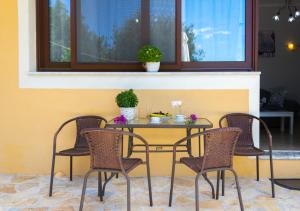 a table and four chairs in a room with a window at Anthoula house in Vlachopoulátika