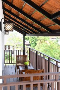 a porch with a table and chairs and a wooden ceiling at El Barrio Lanna in Chiang Mai +159 photos
