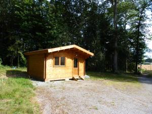 ein kleiner Holzschuppen auf einem Feld in der Unterkunft Chanterelle in Comblessac