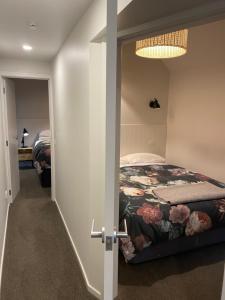 a bedroom with a bed and a door leading into a room at Black Beech House with Stunning Outdoor Bath in Lake Tekapo