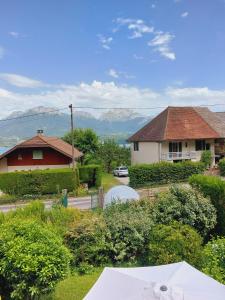 - une vue sur une maison avec des montagnes en arrière-plan dans l'établissement Les Fontanettes, à Sévrier