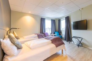 um quarto de hotel com duas camas e uma televisão de ecrã plano em Corner Hotell em Brønnøysund