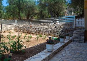 a stone retaining wall with potted plants in a garden at Anthoula house in Vlachopoulátika