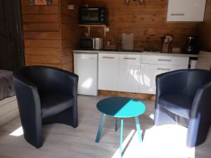 twee stoelen en een tafel in de keuken bij Pied de Mouton in Comblessac
