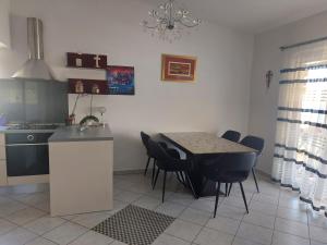 a kitchen with a table and chairs in a room at LARA & VITO in Metajna