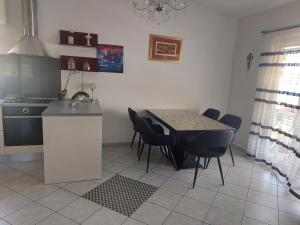 a kitchen with a table and chairs in a room at LARA & VITO in Metajna