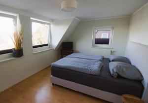 a bedroom with a bed and two windows at Relaxoase ***** in Krakow am See