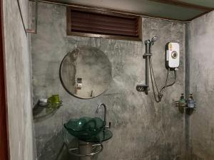 a bathroom with a sink and a mirror at Bansuanphutarn in Ban Pha Saeng Lang