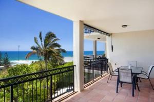 a balcony with a table and chairs and a view of the beach at 3 Hilltop Villas White Water Views from the Heart of Sunshine in Sunshine Beach