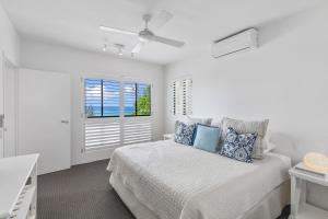 サンシャインビーチにある4 Hilltop Villas Enjoy Ocean Views From The Heart Of The Villageのベッドと窓のある白い寝室 +16枚の写真