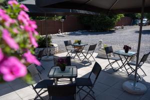 a group of tables and chairs under an umbrella at Hotel Monika in Zutendaal